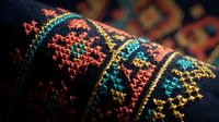 Traditional ethnic embroidery with colorful geometric patterns on dark fabric showcasing intricate needlework and cultural textile art for decorative projects.