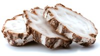 Fresh taro root slices with brown skin and white flesh isolated on white background for cooking and culinary design projects.