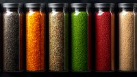 Colorful spices and legumes in glass jars arranged in row. Variety of cooking ingredients including lentils, beans, seeds for culinary preparation.