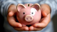 Hands protectively holding pink piggy bank symbolizing financial security, savings protection, and money management for investment planning.