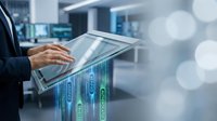 Professional businessman using digital tablet with financial data visualization and charts in modern office environment for business analytics and investment planning.