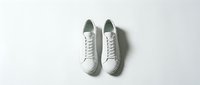 Pair of clean white leather sneakers on a white background, top view. Minimalist casual footwear for fashion, lifestyle, and retail use.