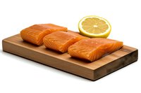 Fresh raw salmon fillets arranged on wooden cutting board with lemon slice, showcasing vibrant orange color and marbled texture for culinary presentation.