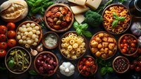 Mediterranean cuisine ingredients in rustic bowls with pasta, olives, tomatoes, herbs and spices arranged on dark wooden table, overhead view of traditional food.