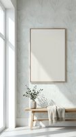 Modern minimalist interior with blank frame on botanical wallpaper, wooden bench with eucalyptus plant and throw blanket near bright window for home decor mockup.
