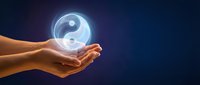 Hands holding glowing yin yang symbol representing balance, harmony, and spiritual wellness for meditation and alternative healing concepts.