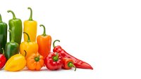 Colorful bell peppers and chili peppers arranged on white background, fresh organic vegetables for healthy cooking and nutrition concepts.