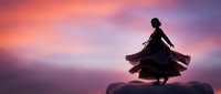 Woman silhouette dancing on mountain peak at sunset with flowing dress against dramatic purple pink sky for wellness and freedom concepts.
