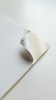 Torn white textured paper with curled edge creating shadow on neutral background for creative design projects and artistic compositions.