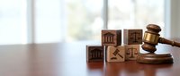 Wooden gavel and legal symbol blocks on desk representing justice, law, court proceedings and legal services for attorneys and law firms.