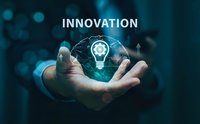 Businessman holding glowing lightbulb with gear mechanism and innovation text representing creative technology solutions and business development concepts.