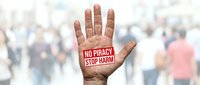 No piracy stop harm message on open palm of person raising hand against blurred crowd background, activism and awareness campaign.