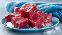 Fresh raw tuna steaks cut into cubes on ice, ready for sashimi or cooking. Premium seafood ingredient for Japanese cuisine and gourmet cooking.