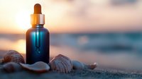 Blue glass dropper bottle with seashells on sandy beach at sunset, ocean waves and golden sky in soft focus background creates serene spa atmosphere.
