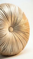Round velvet tufted decorative pillow in warm golden beige tone with pleated texture, isolated on white background for interior design and home decor use.