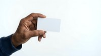 African American male hand holding blank white business card against neutral background for corporate branding and professional identity design.