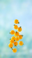 Yellow cherry tomatoes floating in mid-air with green stems against soft blue gradient background, water droplets scattered around, fresh produce arrangement for food and culinary design projects.