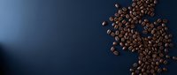 Roasted coffee beans scattered on dark blue background with copy space for beverage, cafe, or food packaging design projects.
