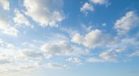Blue sky with white fluffy clouds on sunny day creating peaceful atmosphere for nature backgrounds and weather concepts.