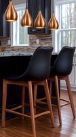Modern kitchen interior with copper pendant lights and black bar stools featuring wooden legs at granite countertop, showcasing contemporary design elements.