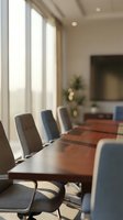 Modern conference room with wooden table and leather chairs in bright office space with natural light from large windows for business meetings.