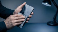 Businessman hands holding smartphone with blank screen at office desk. Mobile technology, communication, digital workspace concept for mockup design.