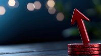 Red metallic arrow pointing upward on stack of coins against dark background with bokeh lights, symbolizing financial growth and investment success.