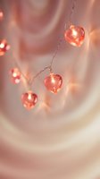 Romantic heart-shaped string lights glowing with warm pink illumination creating cozy atmosphere for Valentine's Day celebration and love-themed decorations.