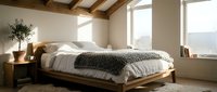 Spacious bedroom with wooden bed frame, white bedding, gray throw blanket, wooden nightstand, potted plant, and large windows with natural light.
