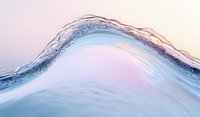Crystal clear ocean wave with soft pink sunset sky creates serene water surface motion. Gentle curve captures light reflection and transparency in macro photography.