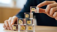 Business professional building wooden blocks with 1% symbols representing gradual growth, investment strategy and financial planning concept.