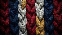 Colorful knitted fabric with braided pattern in navy blue, burgundy red, mustard yellow and white wool. Close up macro texture of winter sweater material.