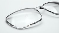 Clear eyeglass lenses with metal frames on white background, optical prescription glasses for vision correction and eye care accessories.