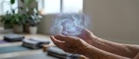 Elderly hands cupping glowing holographic sphere with swirling energy patterns in modern home office setting for technology and innovation concepts.
