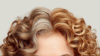 Luxurious curly hair with blonde and brown highlights on white background, showcasing natural waves and volume for hairstyle inspiration.