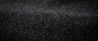 Dark gray herringbone fabric texture with detailed weave pattern for fashion design and textile backgrounds.