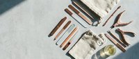 Professional barber tools and grooming equipment arranged on marble surface with natural lighting for salon and barbershop styling services.