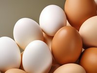 Fresh white and brown chicken eggs arranged together in natural lighting, creating contrast between different colored shells, suitable for food and cooking concepts.