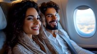 Young Hispanic woman and Middle Eastern man smiling while sitting in airplane seats near window during sunset flight, enjoying travel experience together.