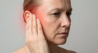 Middle-aged Caucasian woman experiencing ear pain holding hand to inflamed ear showing symptoms of infection or hearing problems for medical content.