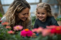 Young mother and daughter enjoying quality time together exploring colorful flowers in garden center, bonding over nature and gardening activities.