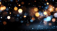 Magical glowing bokeh lights on dark background with blue and golden sparkles creating dreamy atmospheric effect for festive designs and holiday backgrounds.