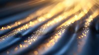 Golden light rays with sparkling particles on dark blue wavy fabric texture, creating magical atmospheric effect for luxury backgrounds.