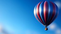 Vibrant red and blue striped hot air balloon soaring through clear blue sky, floating peacefully with soft bokeh effect in background creating dreamy atmosphere.