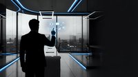 Silhouette of male professional in business suit interacting with digital holographic interface in modern office with city skyline view, representing technology and innovation.