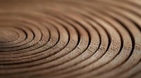 Mesmerizing brown concentric circles pattern with ripple effect and soft shadows creating depth and movement, abstract macro photography background.