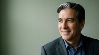 Middle-aged man with dark hair and light skin wearing business casual attire smiling at camera against neutral background for corporate portraits.