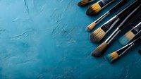 Professional makeup brushes arranged on textured turquoise background with copy space. Natural bristle brushes for cosmetic application and beauty artistry.