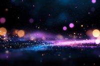 Magical sparkles and bokeh lights on dark background with blue and pink glowing particles creating dreamy atmospheric effect for festive designs.