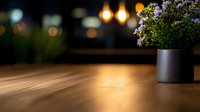 Empty wooden table with purple flowers in black pot against blurred warm bokeh lights background, cozy restaurant atmosphere for product display or montage.